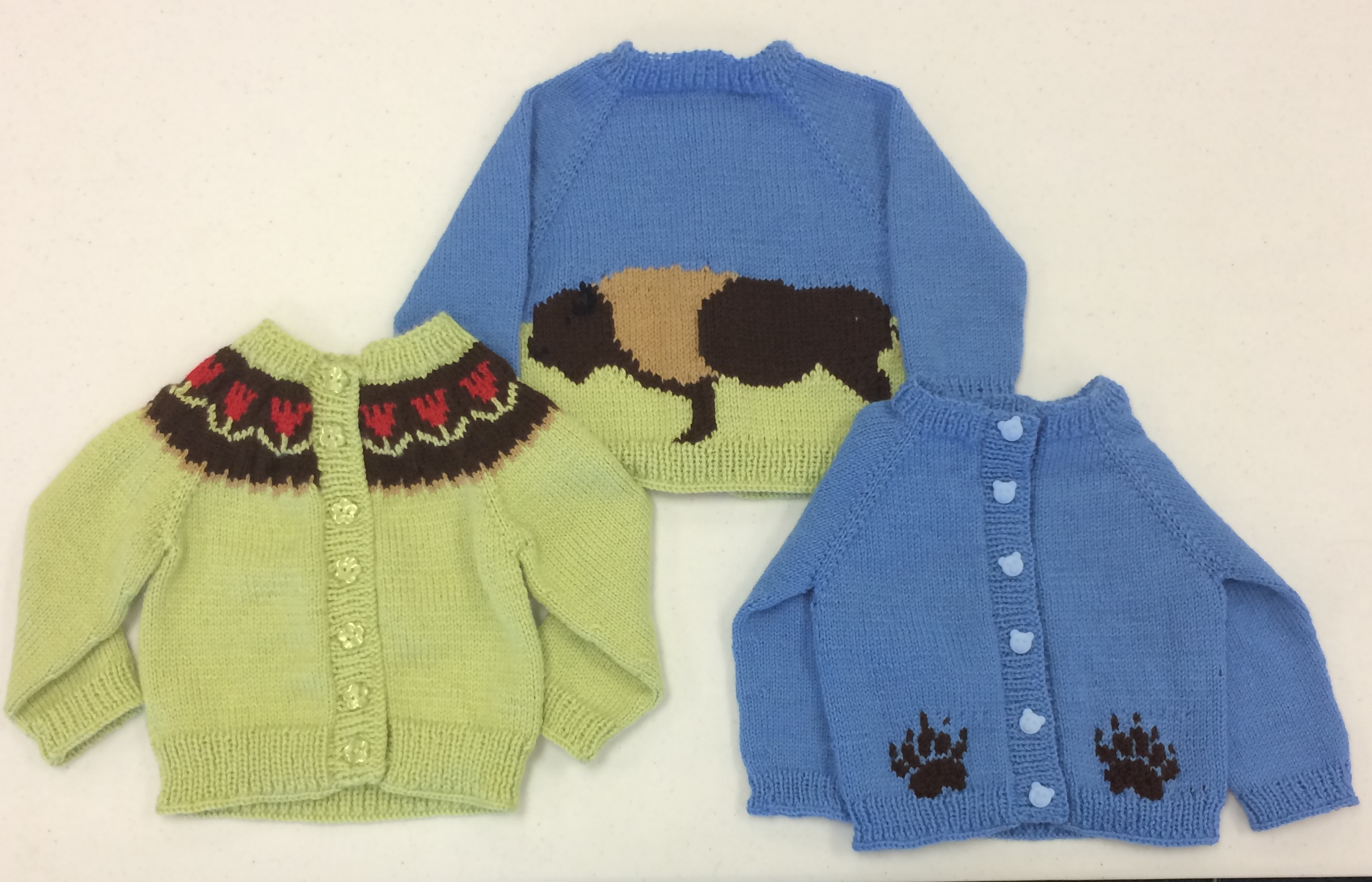 Three baby sweaters